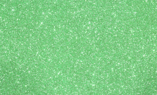 istock Green shimmering glittered background with lights 879051544
