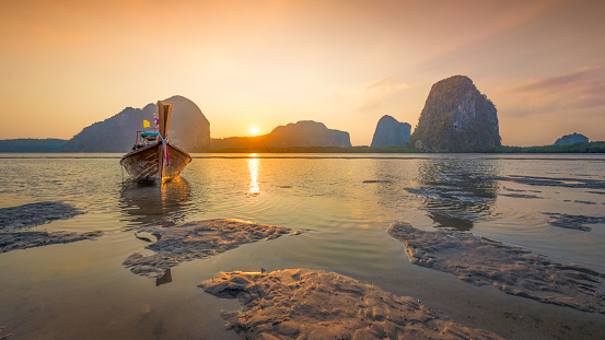 Beautiful sunset at tropical sea with long tail boat in south thailand