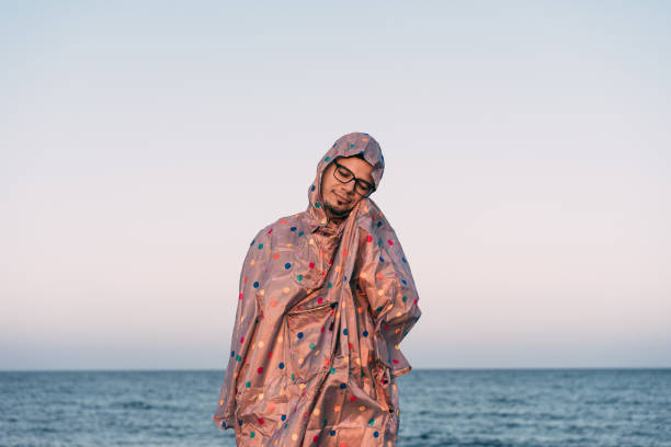 istock Person Standing In Raincoat By Sea Against Clear Sky 879054752