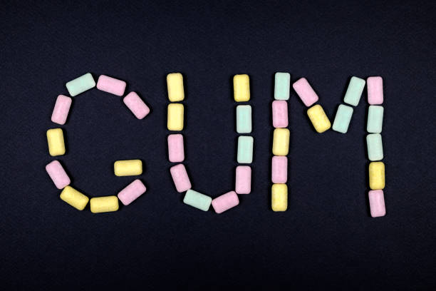 istock Word GUM written with chewing gum on black background 879055082