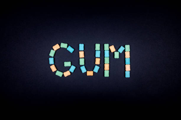 istock Word GUM written with chewing gum on black background 879055088