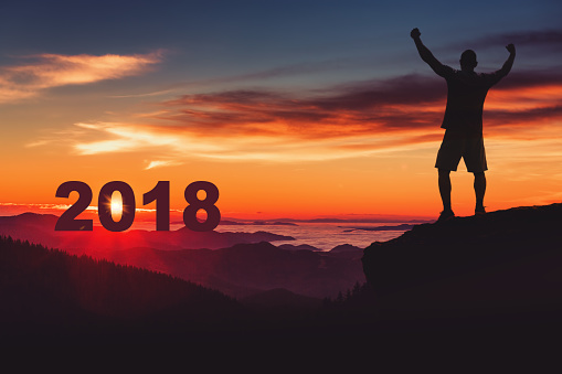 Man silhouette on mountain cliff enjoy panaoramic view. Happy new year 2018 concept.