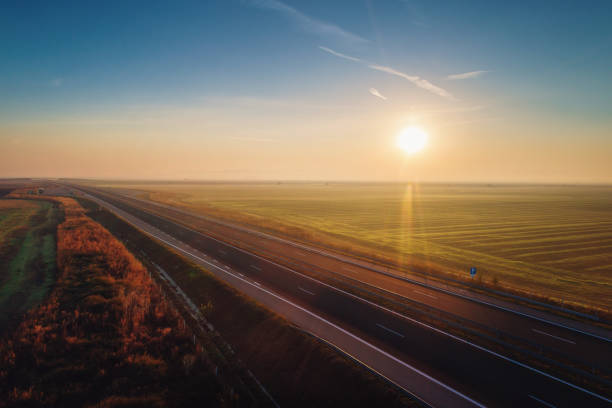 istock Aerial view of highway with forest and fields in fog 879066362