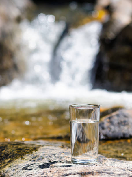 istock Glass of water by waterfall 879066640