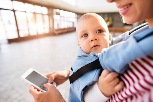 istock Young mother with smartphone and baby travelling. 879070122