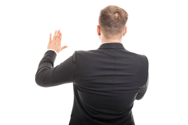 istock Back view of corporate business man with hand raised 879073330