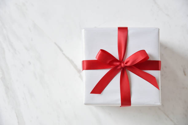istock Top view of white gift box with red ribbon. 879076662