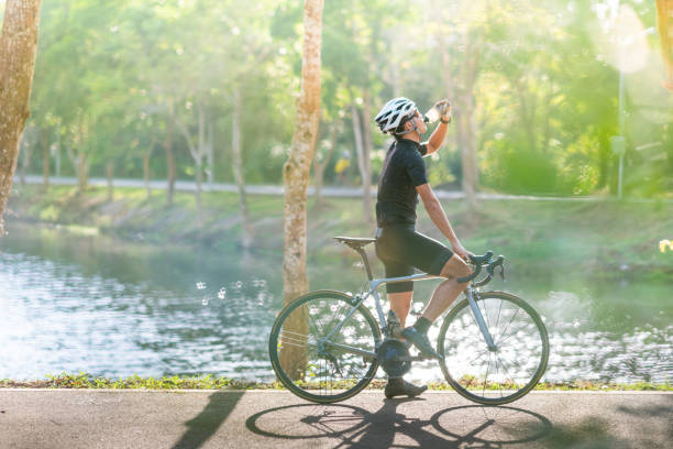 Young man Cyclist riding mountain bike in public park at moring Young man Cyclist riding mountain bike in public park at moring cycling vest photos stock pictures, royalty-free photos & images