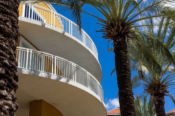 istock Yellow Curved Balconies by Palm Trees 879085720