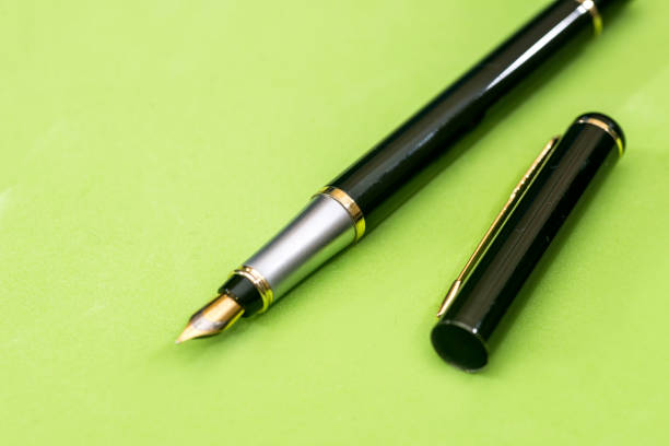 istock pen isolated on green background. Office equipment for paperwork. 879089246