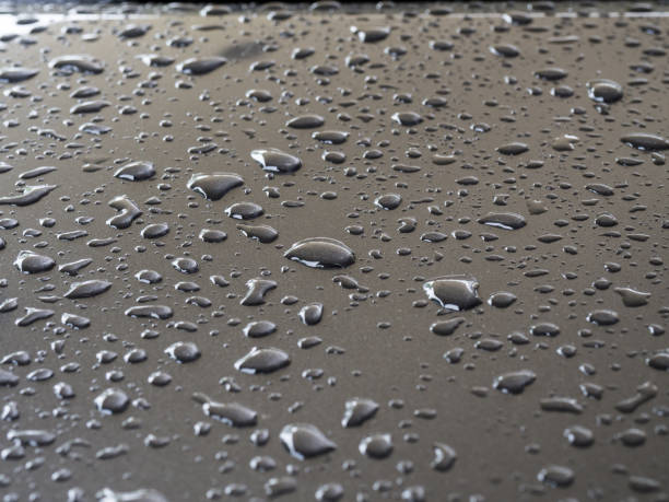 istock closeup to water drops on car metallic surface with lighting background 879094756