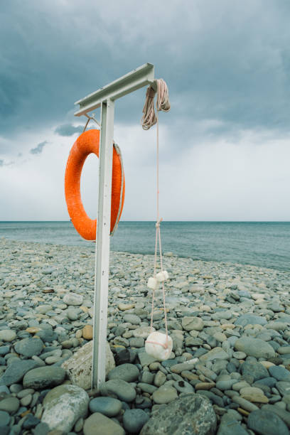 orange lifebuoy on the sea coast on cloudy day