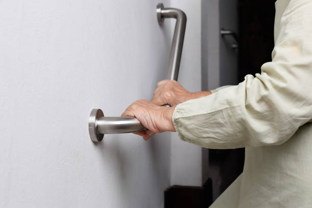 istock Elderly woman holding on handrail for safety walk steps 879108464