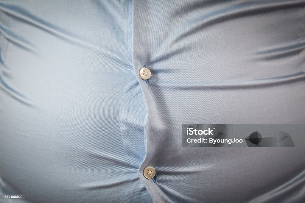 close up of tight shirt, fat man's upper body, unsuccessful dieting and eating wrong foods, diet concepts Overweight Stock Photo