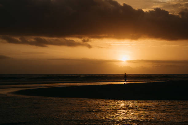 istock Dramatic sunset clouds reflected on the water sea. Tropical beach landscape at golden hour 879112908