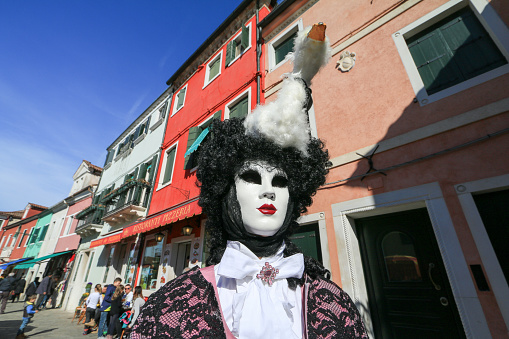 Venice Carnival celebrations lead to masked fancy dress costumes being photographed in the main town square of the island of Burano in Venice