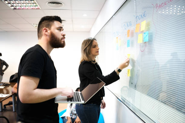 istock Colleagues planning with adhesive notes and laptop in creative office 879125160