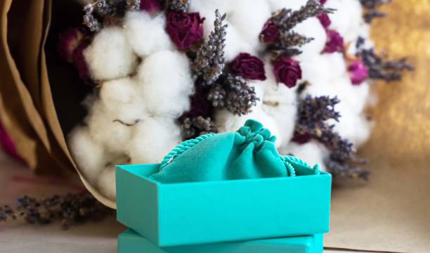 boîte de turquoise pour présent sur fond de fleur - tiffany box photos et images de collection