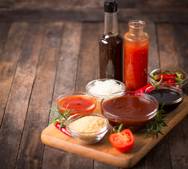 sauce barbecue avec des ingrédients sur la table - condiment photos et images de collection