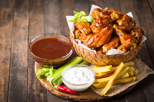 Chicken wings with dips on the wooden table
