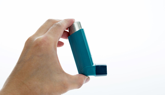 Man hand holding an asthma inhaler