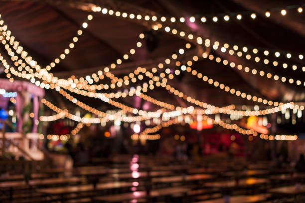 Blurred beer tent, tables, benches, blurry decorative light, London, UK.