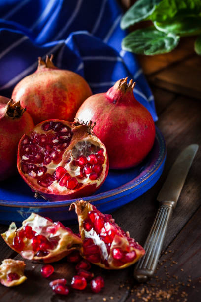 istock Fresh organic pomegranates on rustic wooden table 879154500