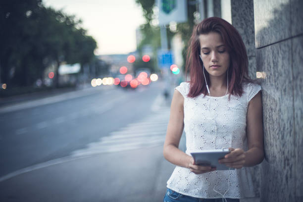 istock Young female student in the city working on her portable information device. 879160996