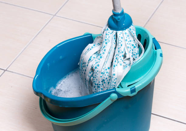 Mop an bucket on tiled floor stock photo