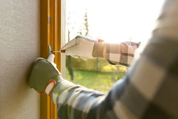Photo of Handyman fixing the window with screwdriver