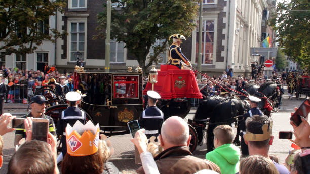 scène van de nederlandse politie, mensen op zoek, nemen foto van leden van de nederlandse koninklijke familie die is zitten binnenkant glas vervoer tijdens prinsjesdag in het europa van de hague.the netherlands.western - prinsjesdag stockfoto's en -beelden
