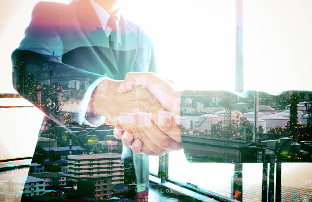 istock Double exposure people shaking hands with oil refinery background 879172714