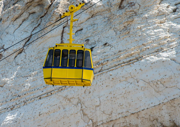 Haifa, Israel, July 10, 2020 : Cabins of the cableway leave the upper station on Mount Carmel against the background of the downtown and the Mediterranean Sea in Haifa in northern Israel