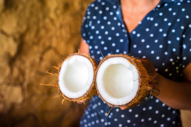 istock Half of coconut in woman's hands 879176164