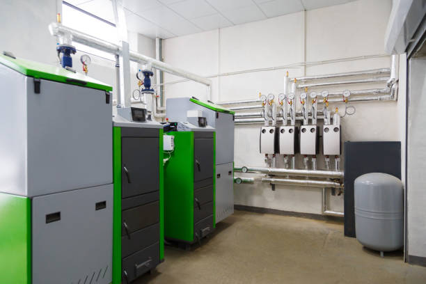 istock Large industrial boiler room with appliance using pallets as a fuel. 879205190