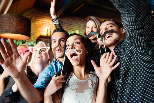 Groupe of people celebrating New Year's Eve and have Happy hour in a bar.  Coworkers and colleagues doing photo booths. Multiethnic group from 25 to 45 year’s old. Pictures was taken in Quebec Canada.