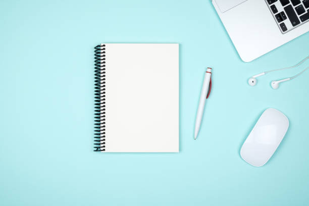 istock Minimal workplace with laptop and blank notepad on colored background. Top view. Flat lay 879223734
