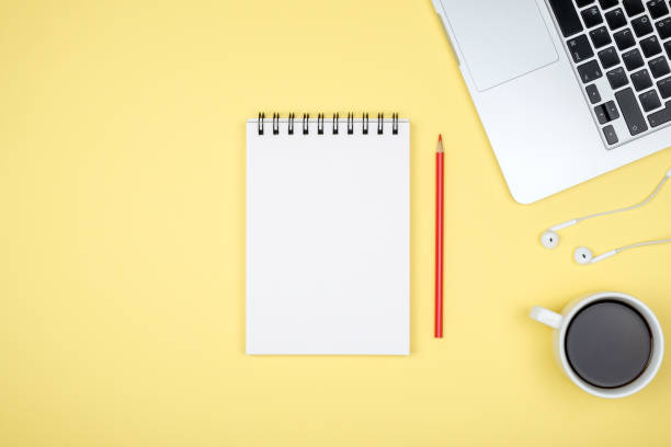 istock Modern yellow office desk table with laptop and blank notebook page for input the text. Top view, flat lay 879223834