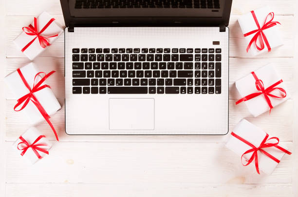istock Laptop and christmas presents on white table flat lay, copy space 879240210