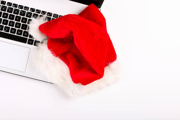 istock Office desk with laptop and santa hat on white background flat lay with copy space. 879240394