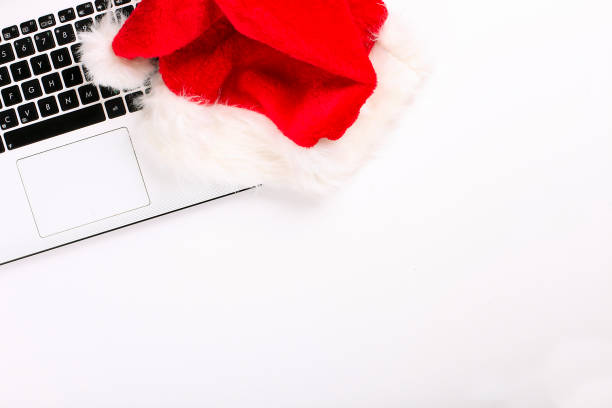 istock Office desk with laptop and santa hat on white background flat lay with copy space. 879240416
