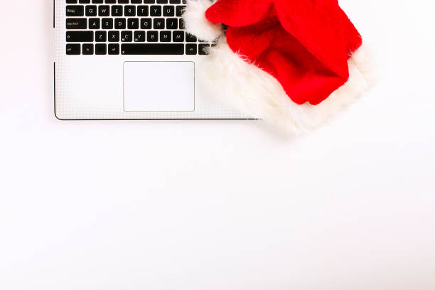 istock Office desk with laptop and santa hat on white background flat lay with copy space. 879240462