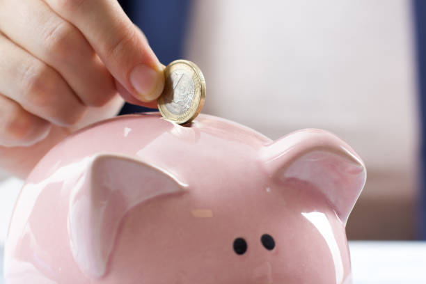 istock Hand putting coin into piggy bank closeup. selective focus 879242798