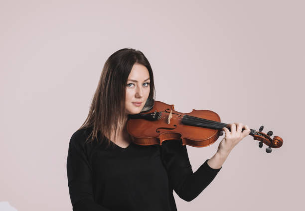 istock Young woman playing violin 879249236