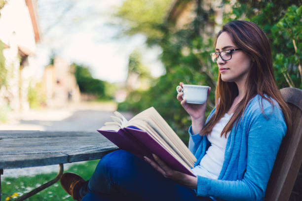 istock Girl reading a book at the backyard 879249692