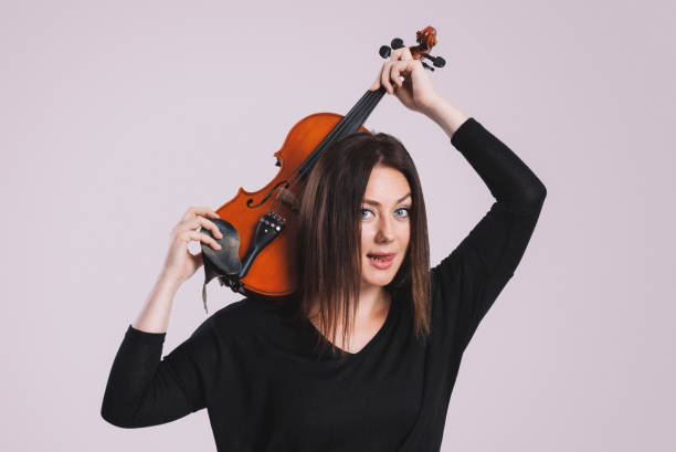 istock Young girl holding violin in her hand 879249772