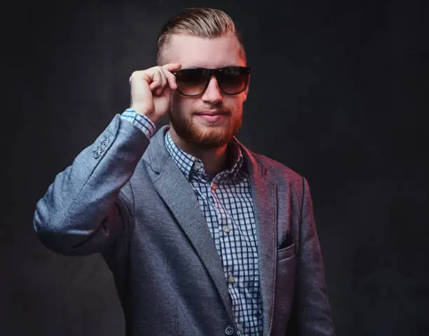 Photo of A man dressed in a suit and sunglasses.