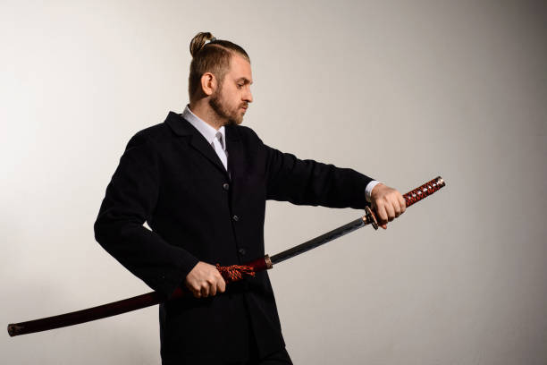 istock businessman in a black suit gets a samurai sword 879254868