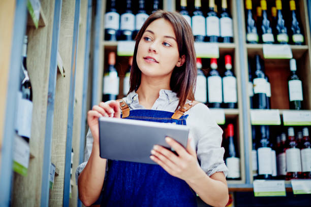 istock Beautiful deli owner holding digital tablet at alcohol section 879257760