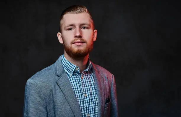 Photo of A man dressed in a suit over grey background.